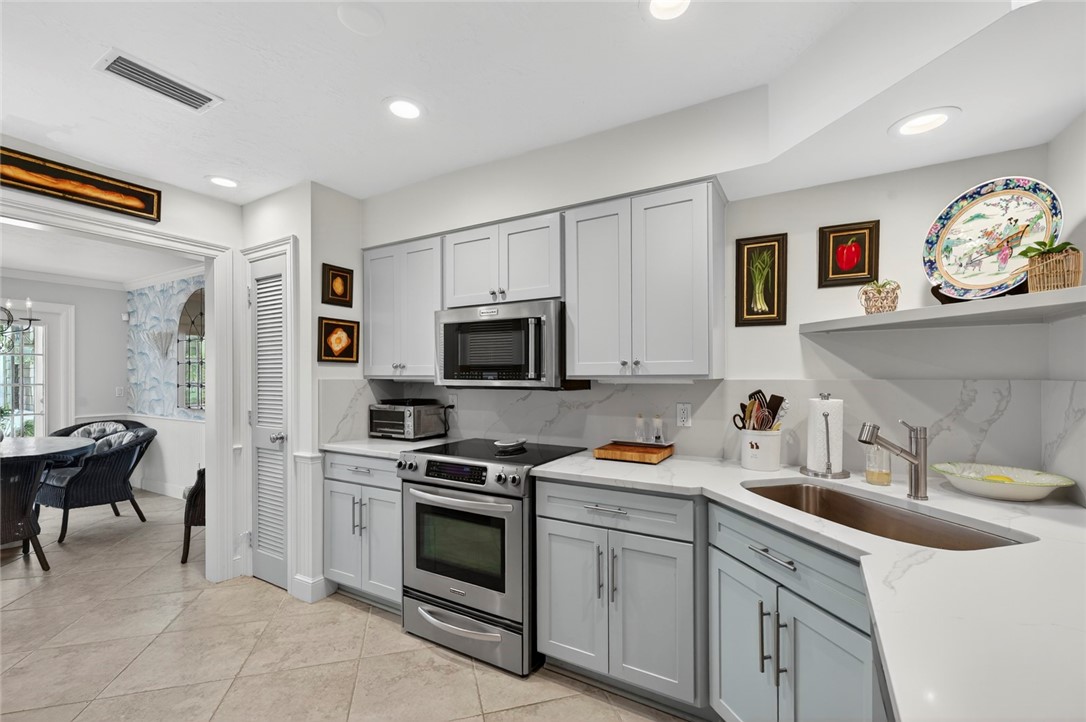 2525 Ocean Drive, Unit 3 Vero Beach, FL 32963 - Photo 9 of 36 a kitchen with stainless steel appliances granite countertop a sink and a stove top oven
