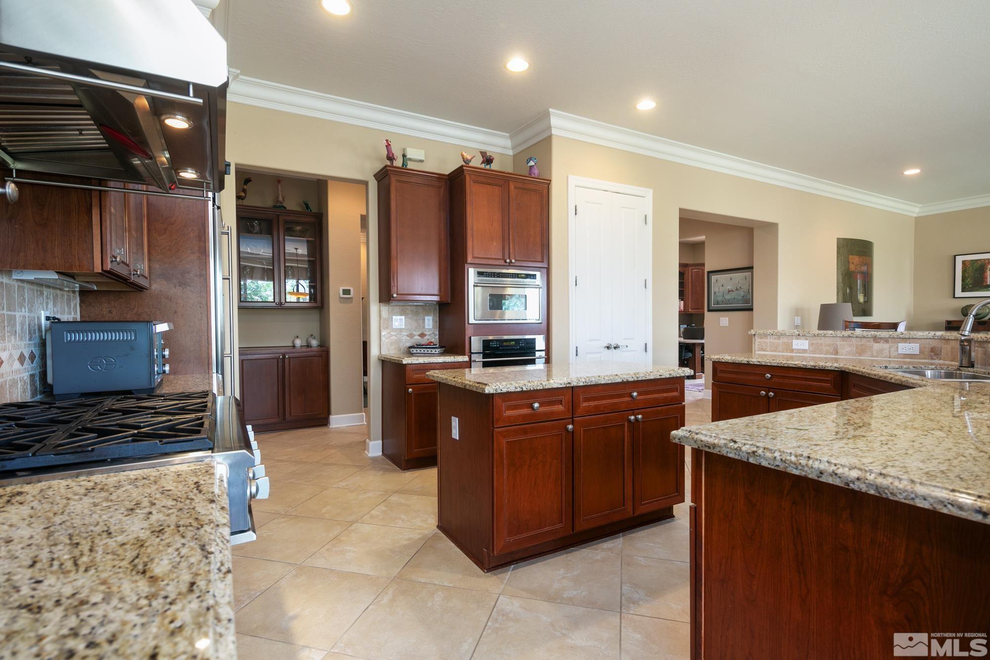 1605 Ashland Bluff Way Reno, NV 89523 - Photo 11 of 37 a large kitchen with stainless steel appliances kitchen island granite countertop a sink and cabinets
