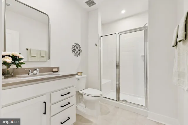 a bathroom with a sink a toilet a mirror and shower