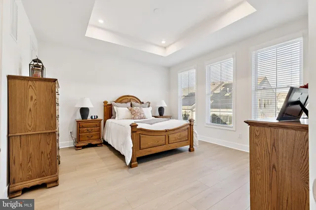 a spacious bedroom with a bed and wooden floor