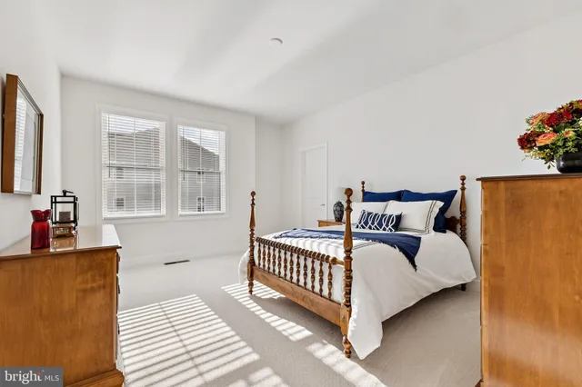 a bed sitting in a bedroom next to a window