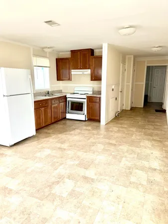 a kitchen with stainless steel appliances a stove top oven a sink a counter top space and cabinets
