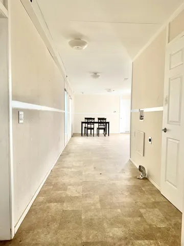 a view of a hallway to a bedroom with wooden floor
