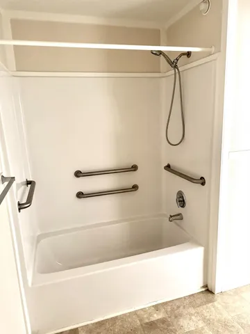 a bathroom with a bath tub with a shower