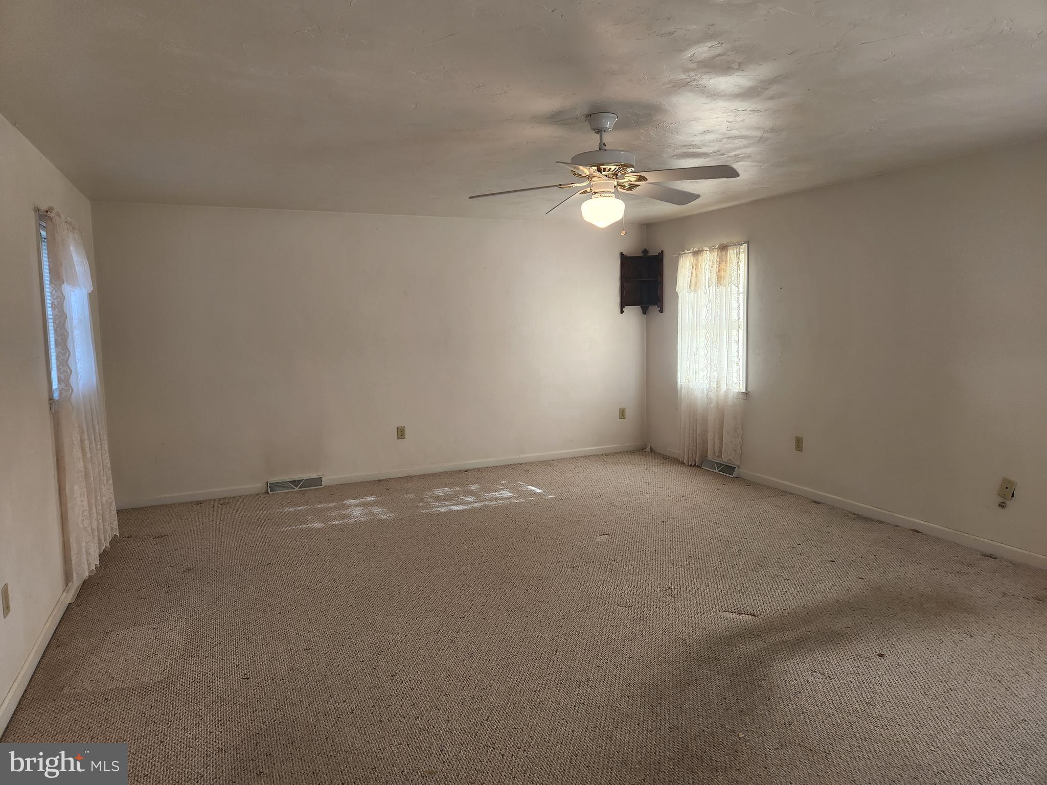 290 Locust Grove Road Bainbridge, PA 17502 - Photo 2 of 108 an empty room with a chandelier fan and windows