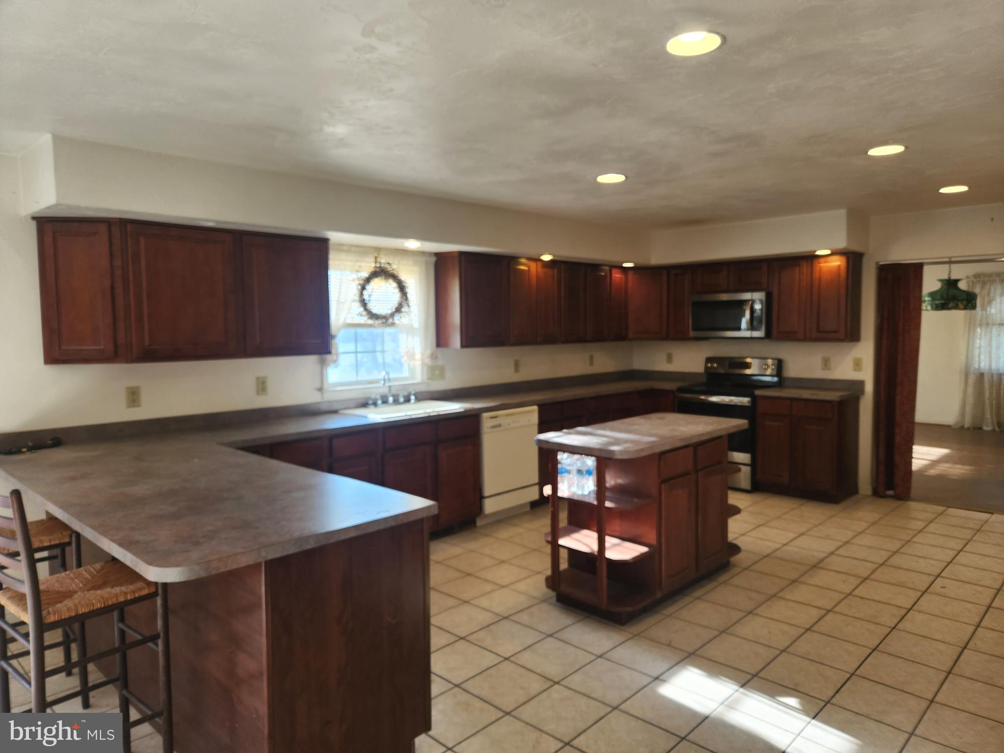 290 Locust Grove Road Bainbridge, PA 17502 - Photo 30 of 108 a kitchen with stainless steel appliances granite countertop a stove a sink and a microwave