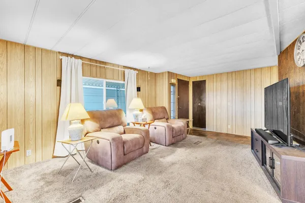 a living room with furniture a large window and a flat screen tv