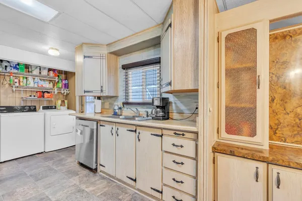 a kitchen with white cabinets and window