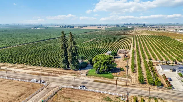 an aerial view of a house with a yard and lake view in back