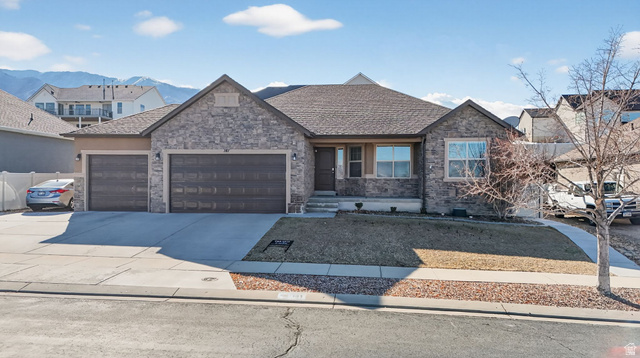 141 Wolverine Creek Elk Ridge, UT 84651 - Photo 39 of 47 View of front of property featuring a garage, driveway, roof with shingles, and stone siding