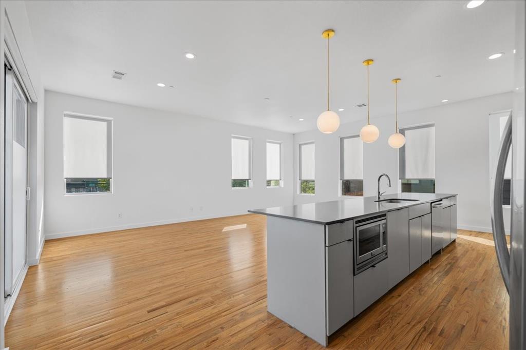 1715 Bennett Avenue, Unit 104 Dallas, TX 75206 - Photo 11 of 35 a kitchen with stainless steel appliances granite countertop a stove and a wooden floors