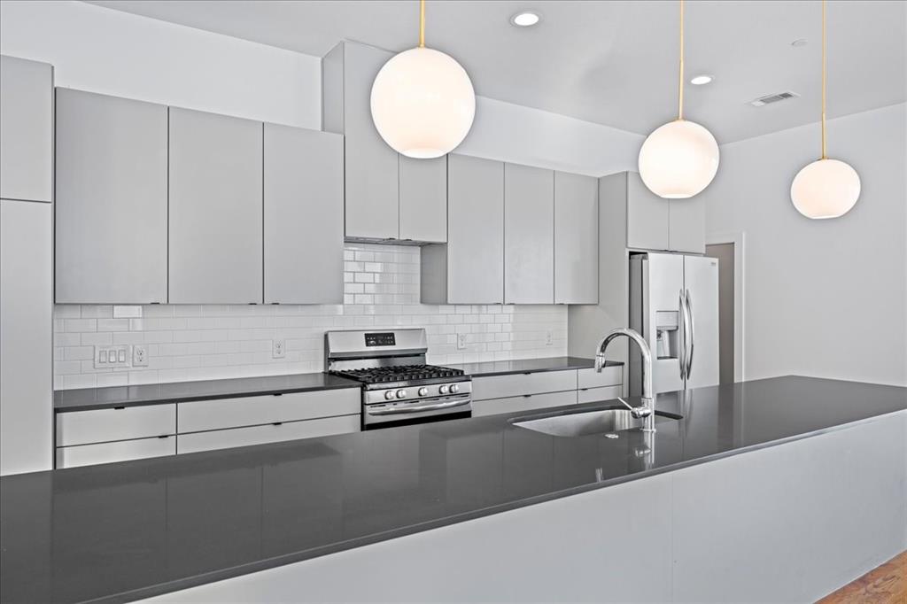 1715 Bennett Avenue, Unit 104 Dallas, TX 75206 - Photo 15 of 35 a kitchen with a sink cabinets and stainless steel appliances