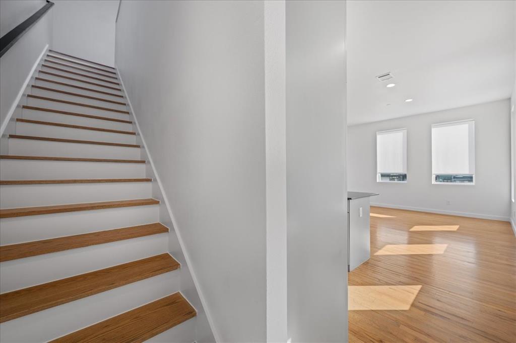 1715 Bennett Avenue, Unit 104 Dallas, TX 75206 - Photo 19 of 35 a view of a hallway with wooden floor and staircase
