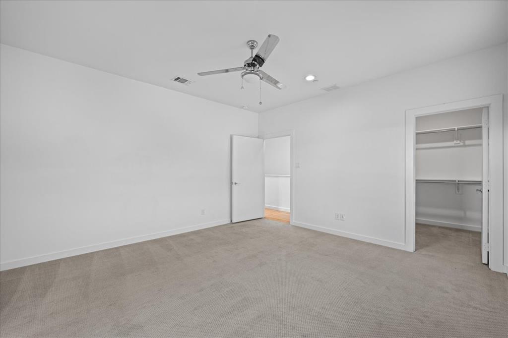 1715 Bennett Avenue, Unit 104 Dallas, TX 75206 - Photo 22 of 35 an empty room with a ceiling fan and a window