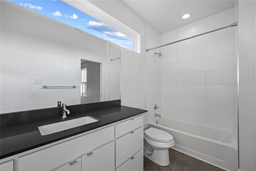 1715 Bennett Avenue, Unit 104 Dallas, TX 75206 - Photo 28 of 35 a bathroom with a sink a toilet and shower