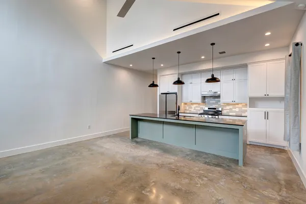 a kitchen with kitchen island a sink appliances and a counter top space
