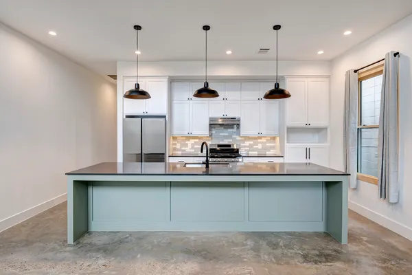 a kitchen with kitchen island white cabinets and stainless steel appliances