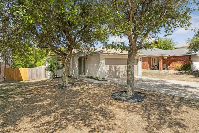 a front view of a house with a tree