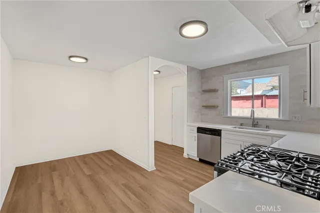a kitchen with granite countertop a stove and wooden floor