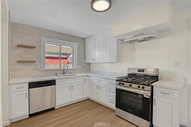 a kitchen with granite countertop cabinets stainless steel appliances and a wooden floor