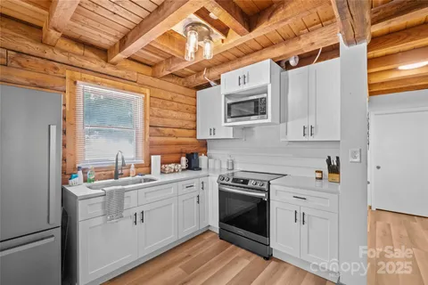 a kitchen with stainless steel appliances granite countertop a sink a stove a microwave and wooden floors