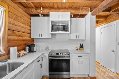 a kitchen with stainless steel appliances a stove a microwave and a sink