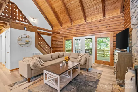 a living room with furniture a flat screen tv and a floor to ceiling window