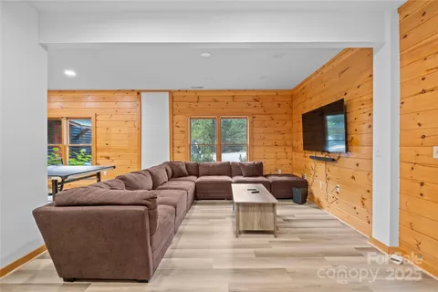 a living room with furniture wooden floor and a flat screen tv