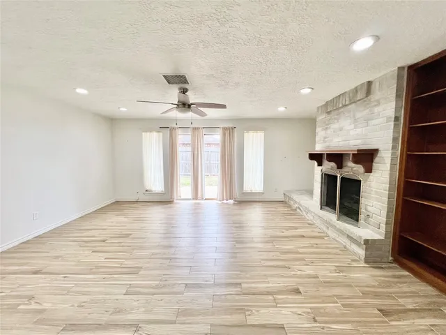 an empty room with wooden floor and fireplace