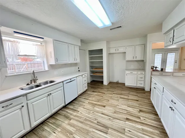 a large kitchen with kitchen island granite countertop a sink and cabinets