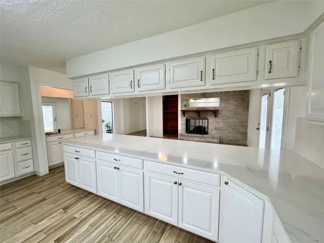 a kitchen with granite countertop white cabinets and stainless steel appliances