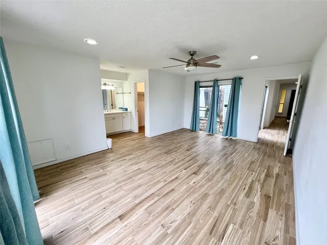 a view of a hallway with wooden floor and chandelier
