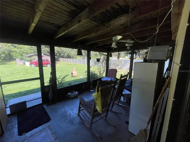 a view of a porch with furniture and a floor to ceiling window