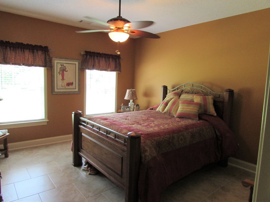 7440 Goodall Mill Road Macon, GA 31216 - Photo 23 of 33 a spacious bedroom with a bed and a chandelier