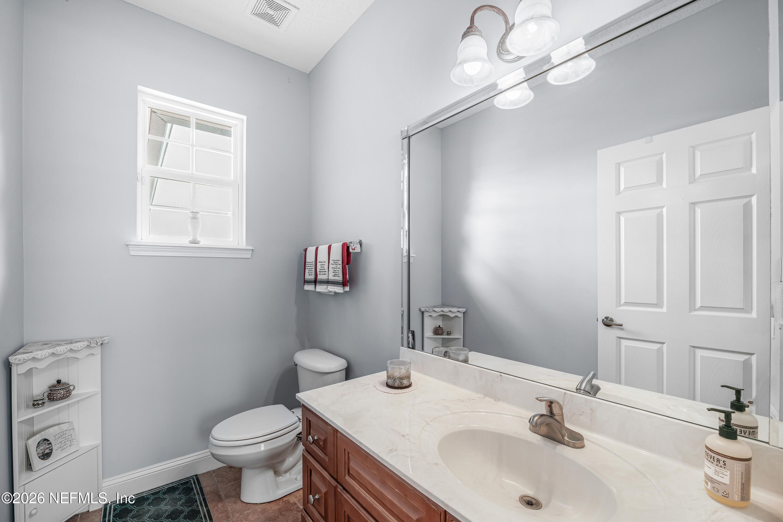 371154 Kings Ferry Road Hilliard, FL 32046 - Photo 37 of 65 a bathroom with a toilet sink and mirror