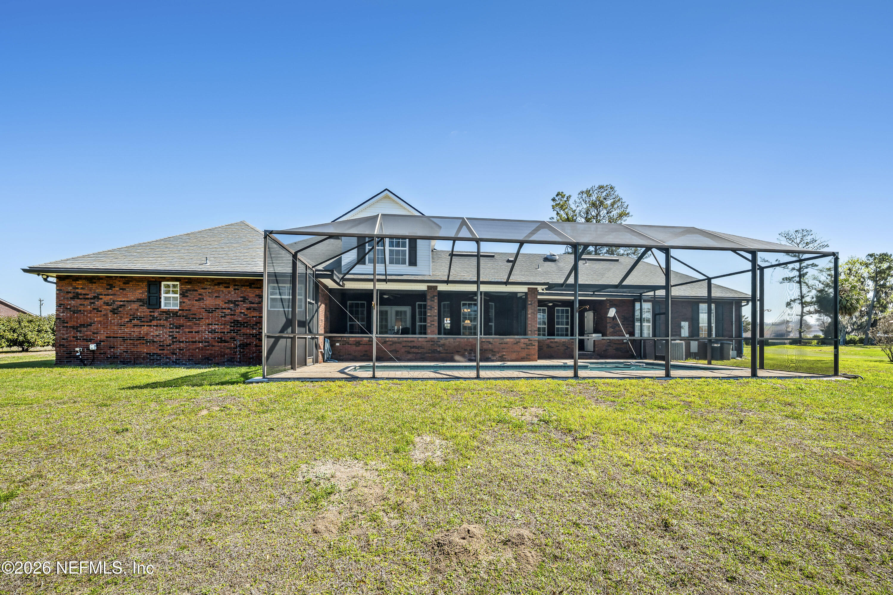 371154 Kings Ferry Road Hilliard, FL 32046 - Photo 52 of 65 a view of a large pool with a bench and lawn chair under large tree