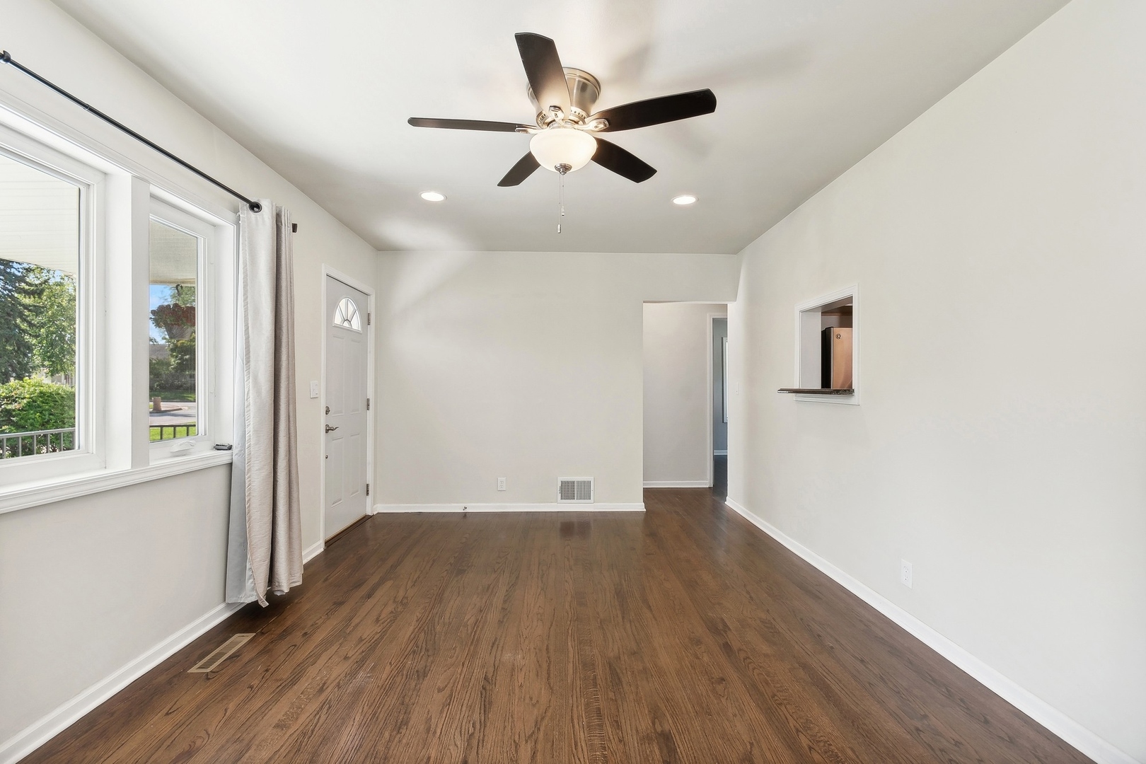 1513 Marquette Road Joliet, IL 60435 - Photo 3 of 16 a view of an empty room with window and wooden floor