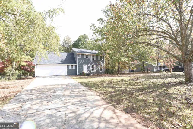 a front view of a house with a yard and covered with snow