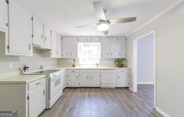 a kitchen with cabinets stainless steel appliances a sink and a window
