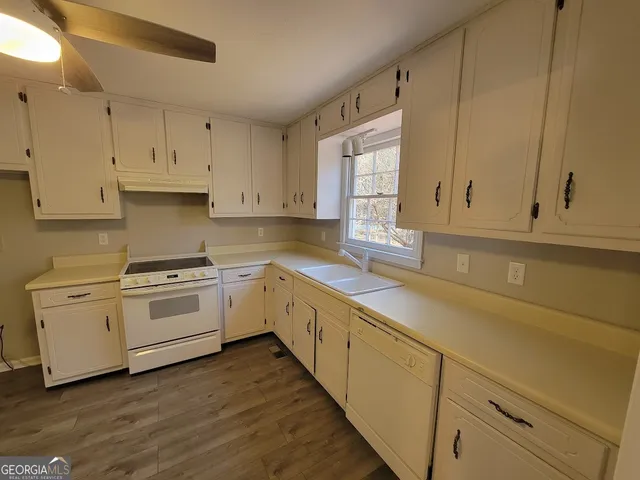 a kitchen with cabinets appliances a sink and a window