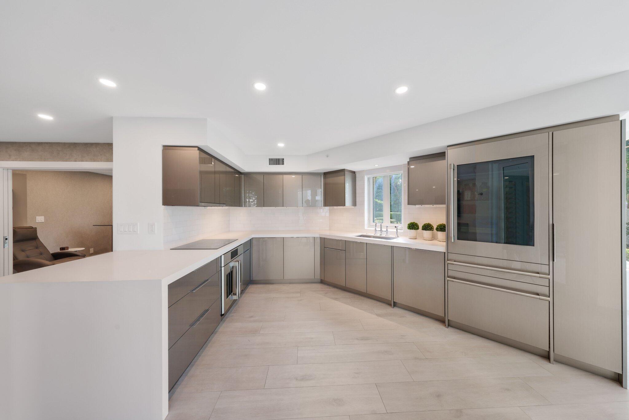 100 Southeast 5th Avenue, Unit 106 Boca Raton, FL 33432 - Photo 12 of 81 a large white kitchen with a large window