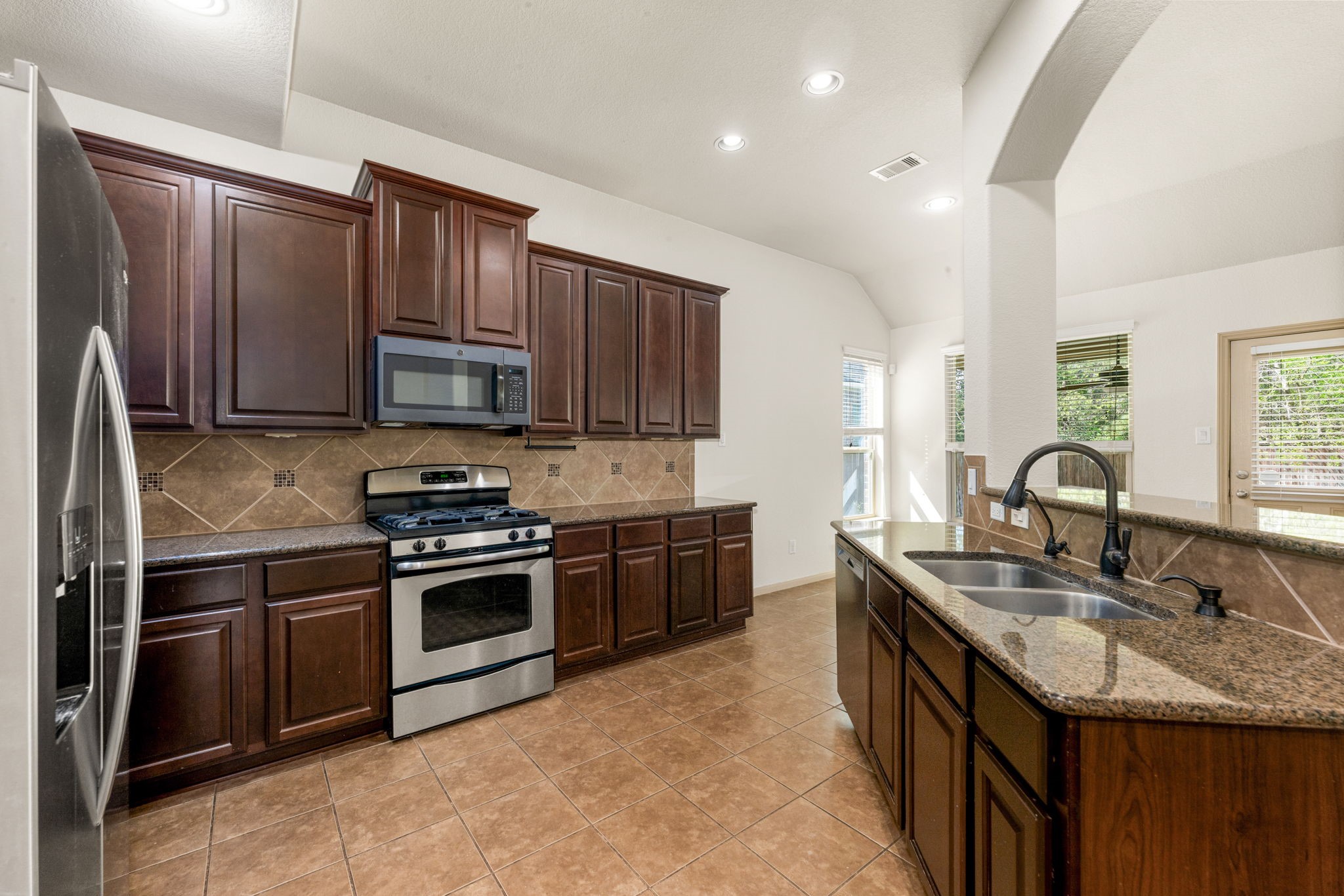 51 Handbridge Place Tomball, TX 77375 - Photo 13 of 46 a kitchen with stainless steel appliances granite countertop a sink stove and refrigerator
