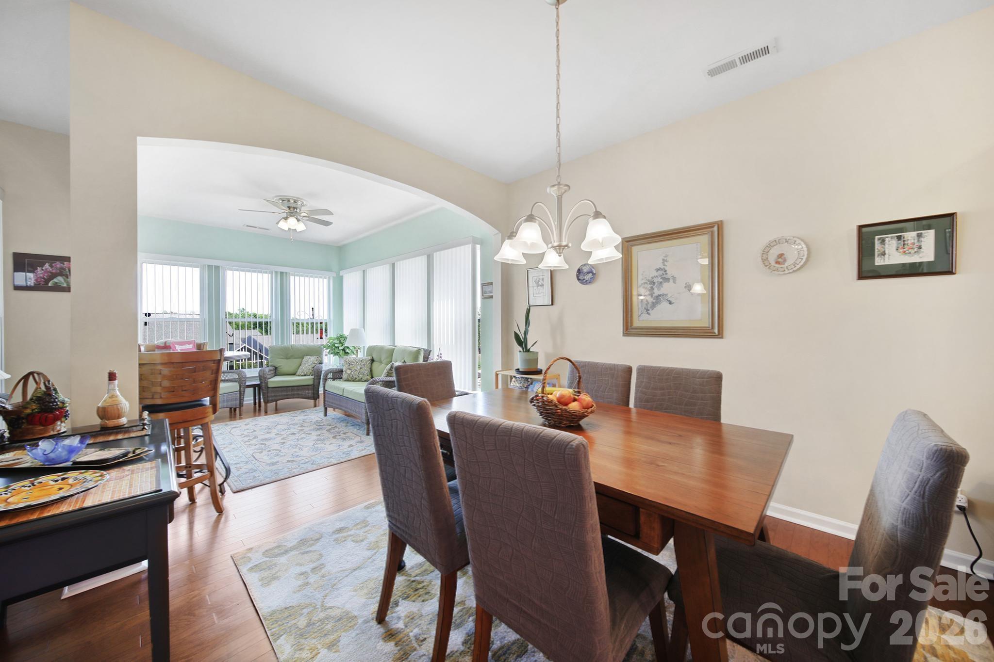 8080 Pawleys Court Fort Mill, SC 29707 - Photo 11 of 44 a view of a dining room with furniture a chandelier and wooden floor
