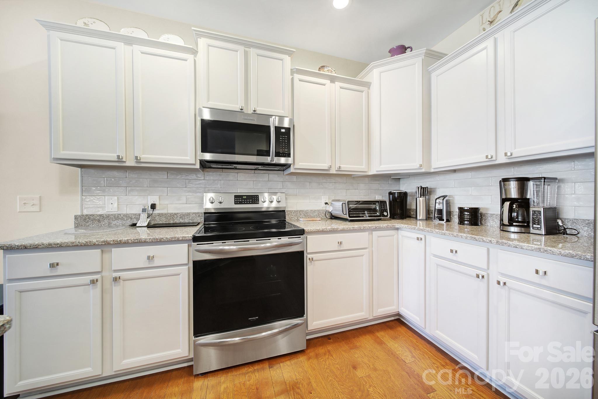 8080 Pawleys Court Fort Mill, SC 29707 - Photo 6 of 44 a kitchen with stainless steel appliances granite countertop a stove a sink and white cabinets