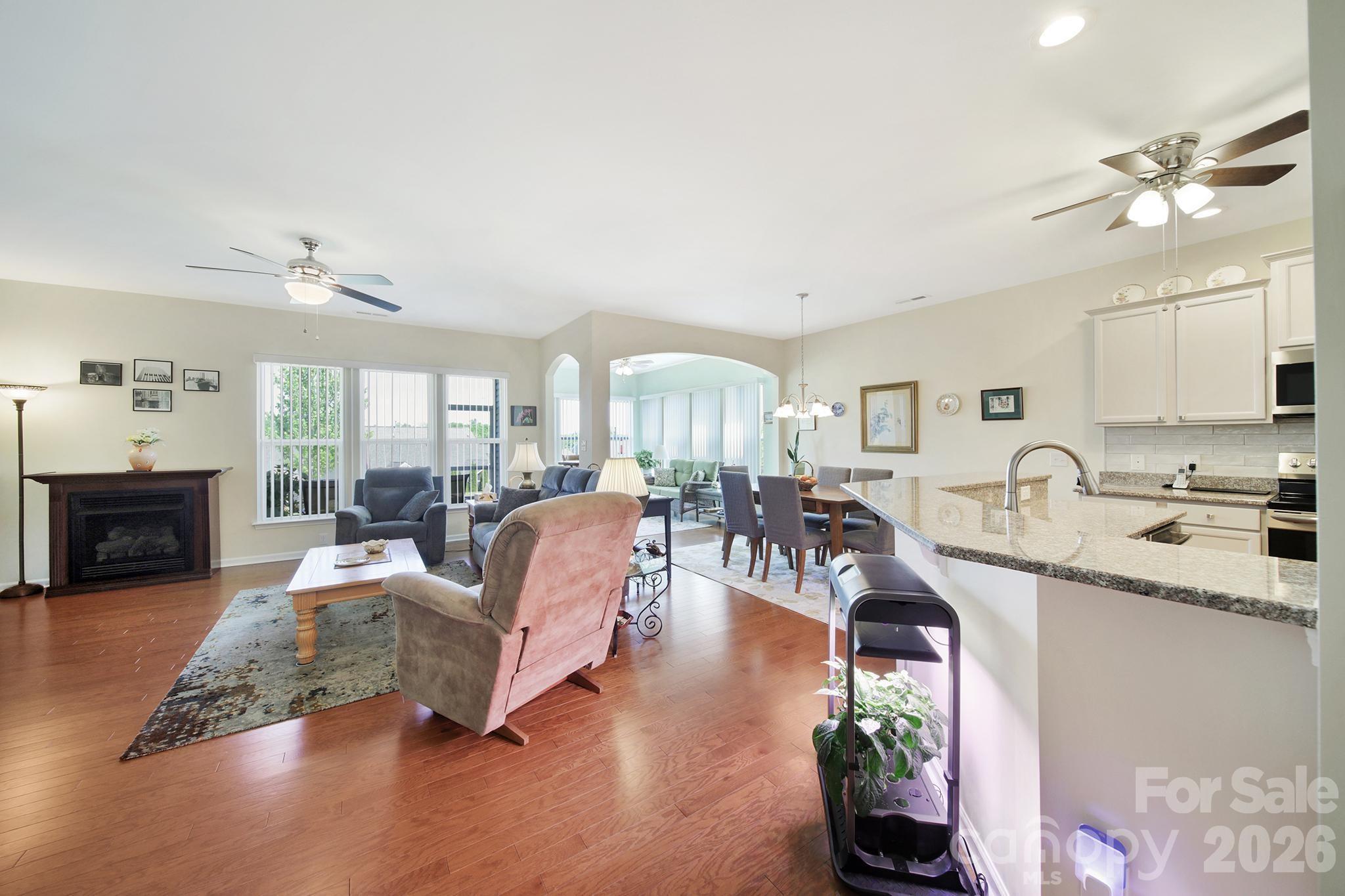 8080 Pawleys Court Fort Mill, SC 29707 - Photo 8 of 44 a living room with furniture a fireplace and a chandelier