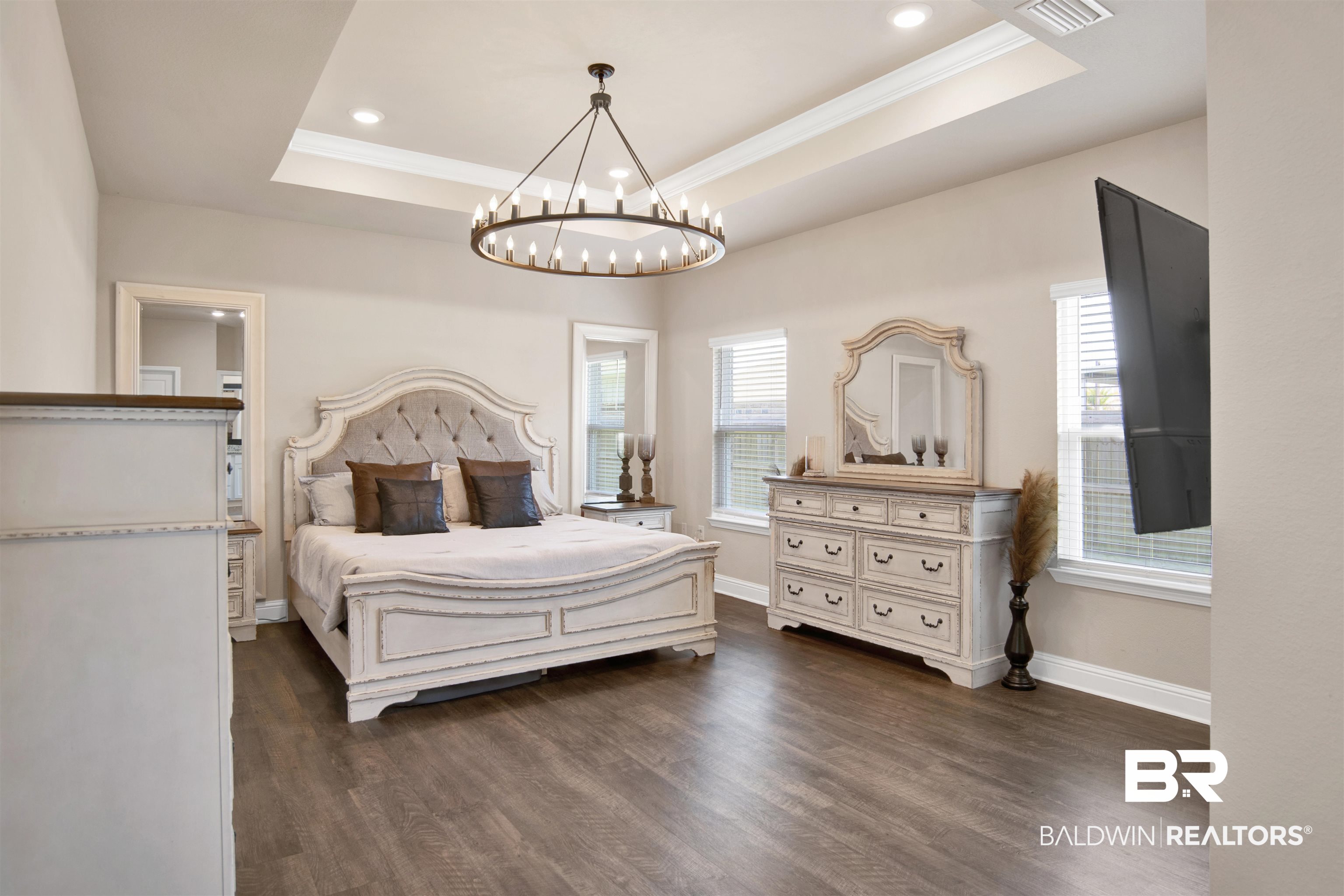 8493 Bronze Lane Foley, AL 36535 - Photo 17 of 38 Spacious room featuring wood-finish flooring, a tray ceiling with recessed lighting, and a large circular chandelier