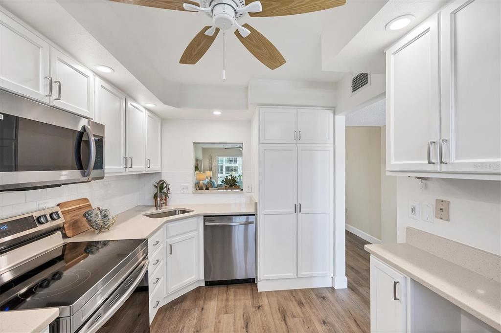 210 Santa Maria Street, Unit 248 Venice, FL 34285 - Photo 15 of 72 a kitchen with a sink a microwave a stove and white cabinets