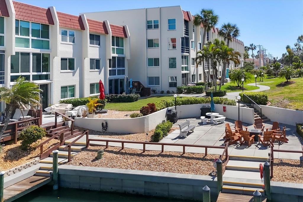 210 Santa Maria Street, Unit 248 Venice, FL 34285 - Photo 45 of 72 a view of a patio with couches table and chairs potted plants and palm tree