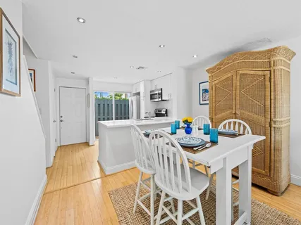 a view of a dining room with furniture a rug and wooden floor