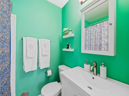 a bathroom with a sink mirror and a toilet